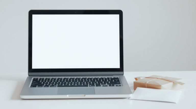 Laptop su scrivania bianca con modulo web che si compila in automatico, buste e pacco accanto: autofill AI per i moduli
